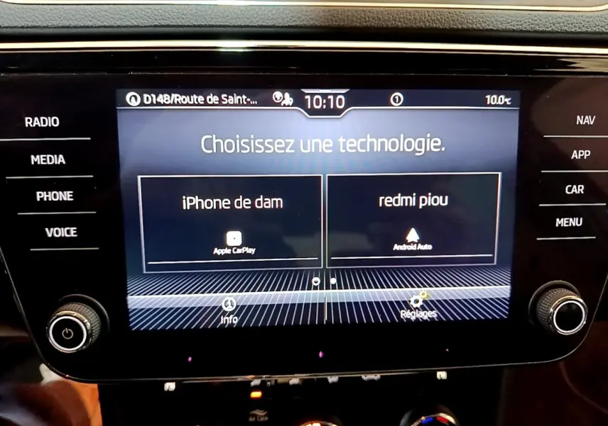 Écran tactile central de la Skoda Superb blanc, affichant le choix entre Apple CarPlay et Android Auto.