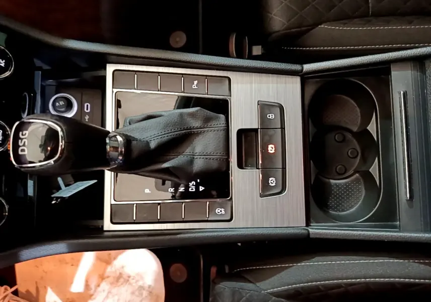 Vue rapprochée de la console centrale noire avec levier de vitesse DSG et porte-gobelets de la Skoda Superb 2021.