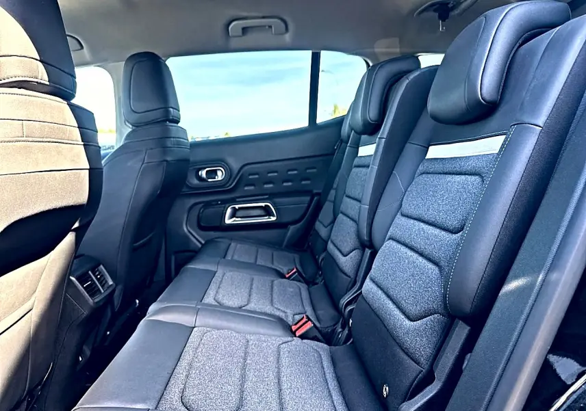 Vue latérale intérieure sur la 2e rangée de sièges individuels noirs et gris du Citroën C5 Aircross 2025.