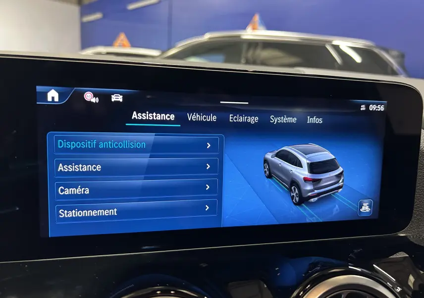 Écran tactile intérieur montrant l'assistance au stationnement d'un Mercedes GLA 200 D AMG Line argent, vue 3/4 arrière.