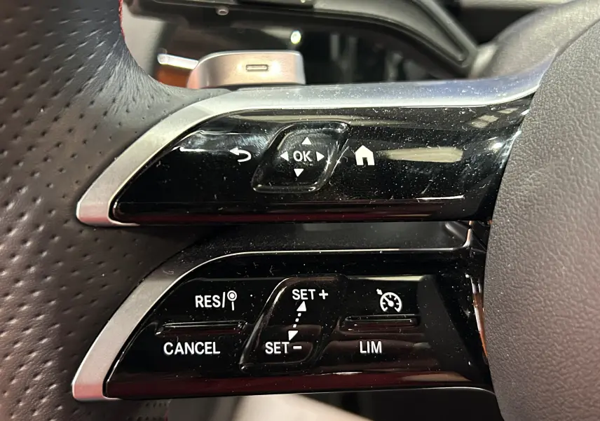 Gros plan sur les commandes au volant noir et argent du Mercedes GLA 200 D AMG Line 2024, finition sportive