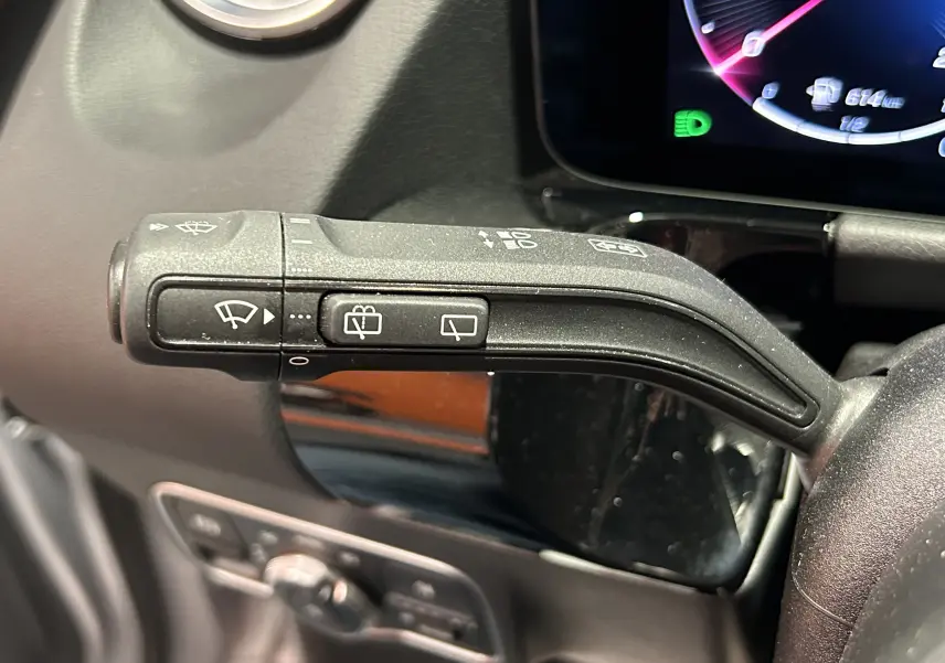 Gros plan sur la commande d’essuie-glace à gauche du volant dans l’habitacle du Mercedes GLA 200 D argent High-tech 2024