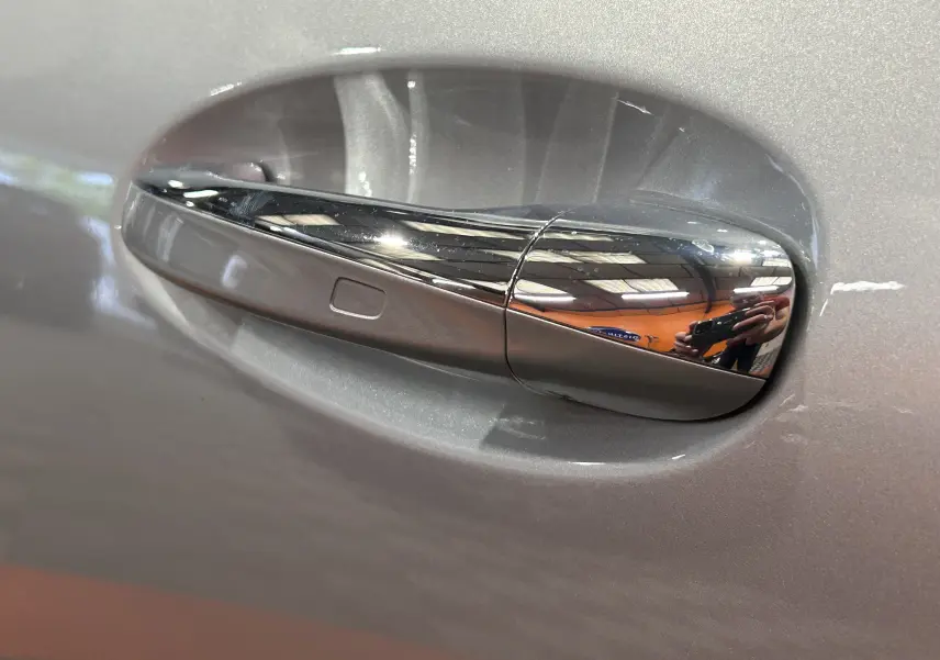 Poignée de porte argentée chromée sur Mercedes GLA 200 D AMG Line 2024, finition High-tech, détail du côté gauche.