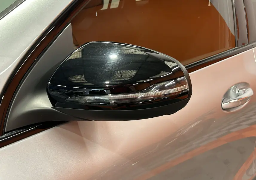 Rétroviseur noir brillant côté gauche d'une Mercedes GLA 200 D AMG Line argent High-tech, vue rapprochée sur porte et poignée.