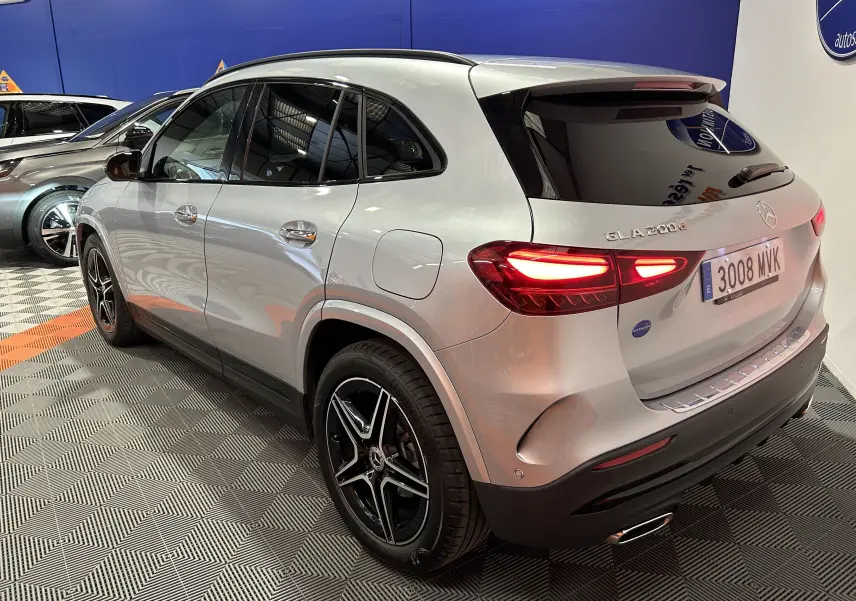 Vue 3/4 arrière droite d'un Mercedes GLA 200 d AMG Line argent métallisé avec jantes AMG noires et vitres teintées.