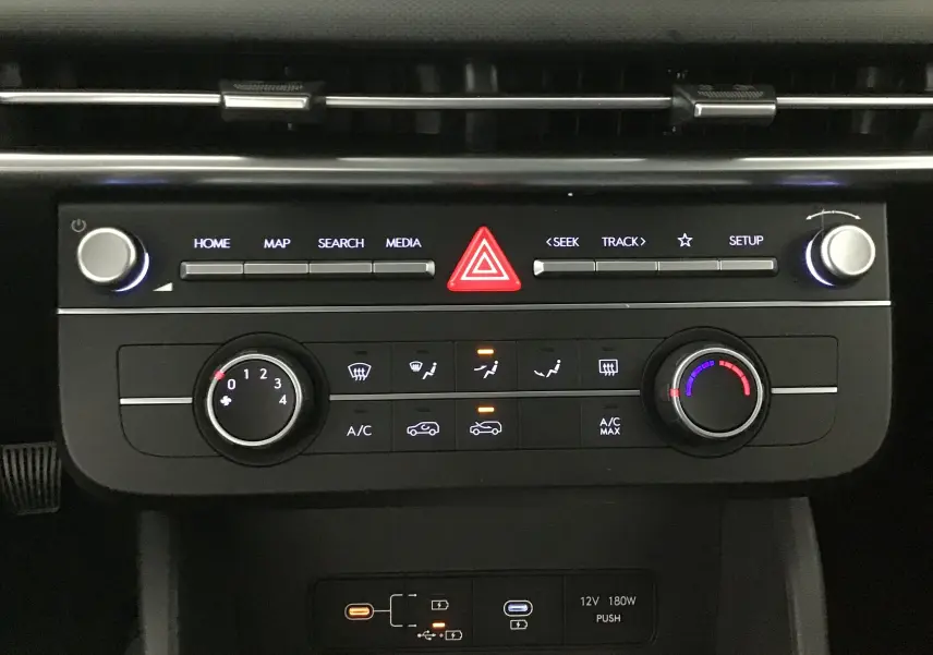 Panneau de commande central du Hyundai Tucson 2025 avec climatisation et boutons média en vue frontale rapprochée.