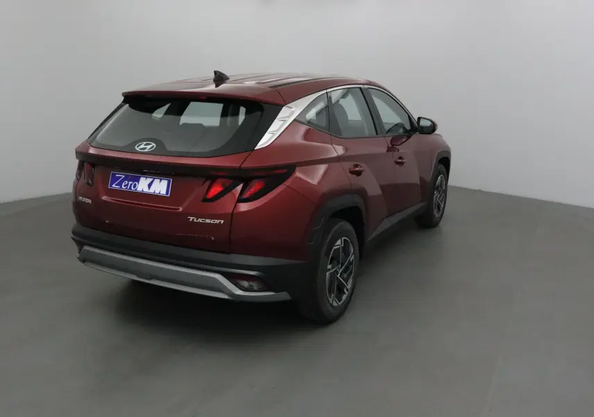 Vue 3/4 arrière droite d’un Hyundai Tucson 2025 rouge Ultimate avec feux arrière LED et jantes alliage noires.