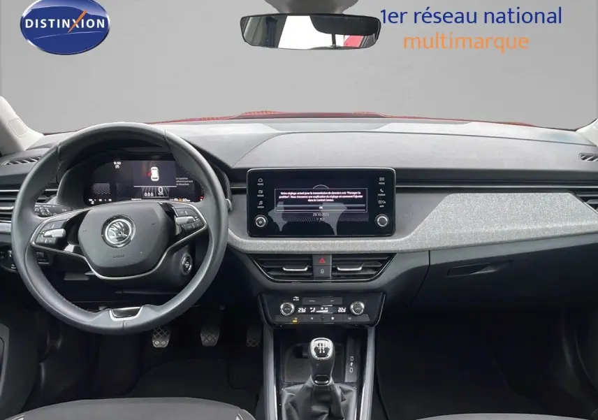 Intérieur de la Skoda Kamiq 2024 rouge velvet metal, vue frontale sur le tableau de bord et levier de vitesse manuel.