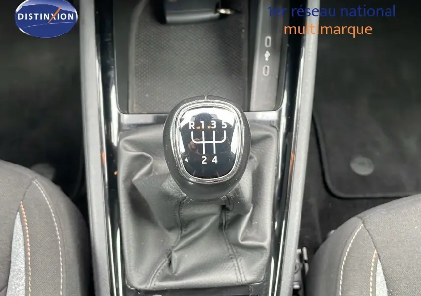 Le levier de vitesses manuel du Skoda Kamiq 2024 en vue plongeante, entouré de sièges en tissu gris.