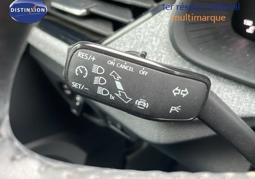 Gros plan sur la commande de régulateur de vitesse dans l'habitacle du Skoda Kamiq rouge Velvet Metal 2024.