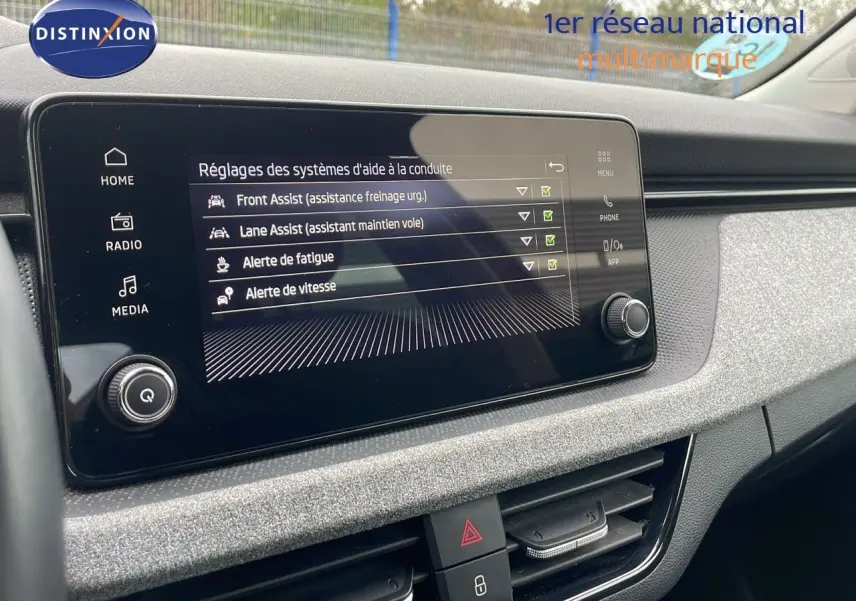 Écran tactile central du tableau de bord du Skoda Kamiq 2024 affichant les aides à la conduite activées.