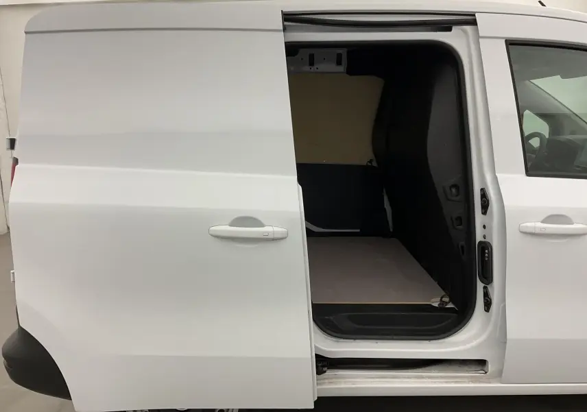 Vue latérale droite d'un Renault Kangoo Van blanc 2024 avec porte coulissante ouverte montrant l'espace de chargement vide.