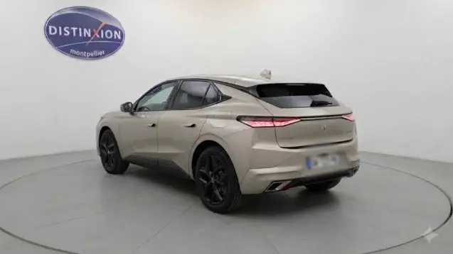 Vue 3/4 arrière droite d’un DS4 gris 2024 hybride E-Tense avec feux arrière fins et jantes noires.