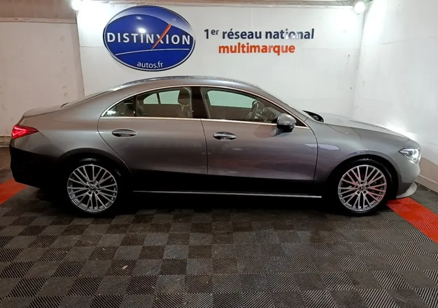 Vue de profil côté gauche d'une Mercedes CLA 180 d Business Line gris clair dans un showroom intérieur.