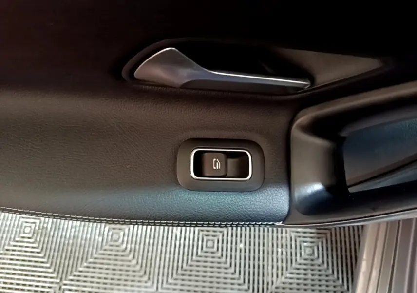 Détail de la commande de verrouillage sur la porte intérieure côté conducteur d’une Mercedes CLA 180 d Business Line gris clair.