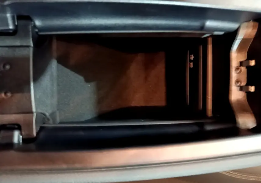 Vue rapprochée de l'accoudoir central ouvert d'une Mercedes CLA 180 d Business Line gris clair, intérieur noir.