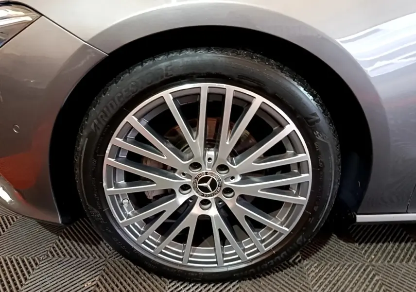 Gros plan sur la roue avant gauche gris clair d'une Mercedes CLA 180 d Business Line avec jante alliage multi-branches.