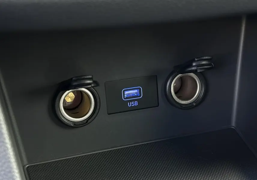 Gros plan sur la prise USB et les deux allume-cigares dans l'habitacle noir de la Hyundai i30 SW T-GDI 120 Modern.