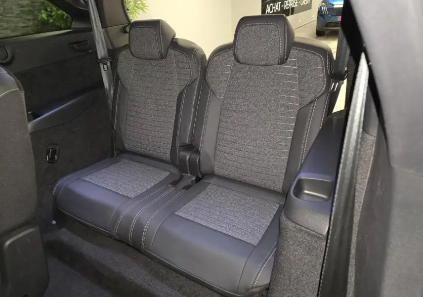 Banquette 2 places arrière en tissu gris et cuir noir dans un Peugeot 5008 blanc, vue de côté droit intérieur.