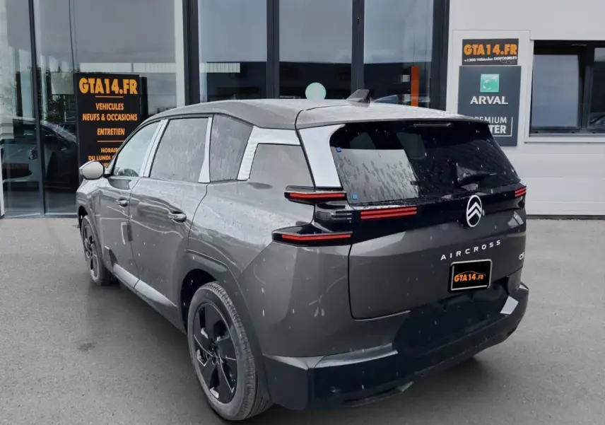 Vue 3/4 arrière droite d'un Citroën C5 Aircross gris platinium avec feux arrière horizontaux et jantes noires.