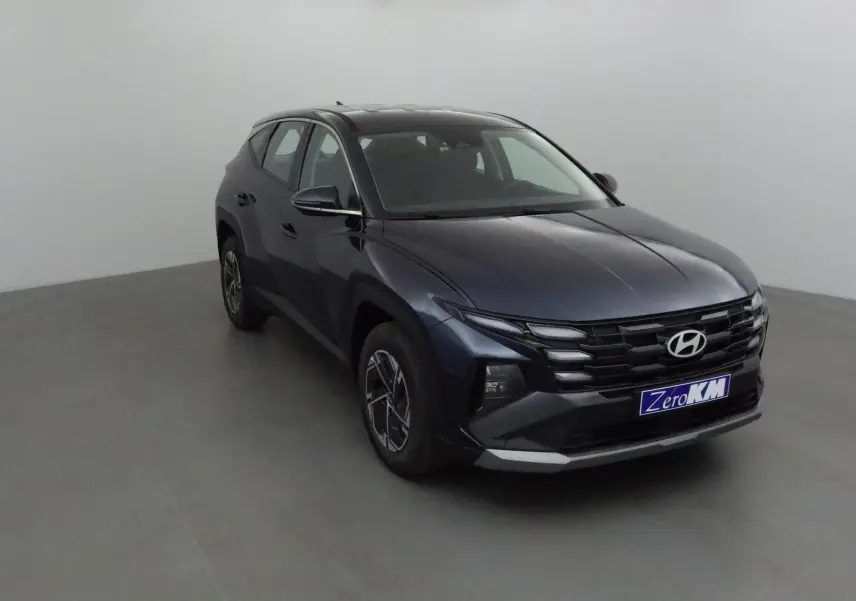 Hyundai Tucson 2025 bleu salling vu en 3/4 avant droit, avec calandre noire et jantes alliage distinctives.