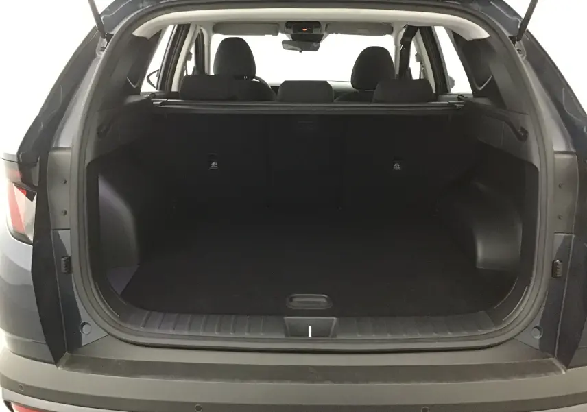 Coffre ouvert vu de l'arrière du Hyundai Tucson 2025 bleu Salling, montrant l'espace de chargement vide et les sièges arrière.