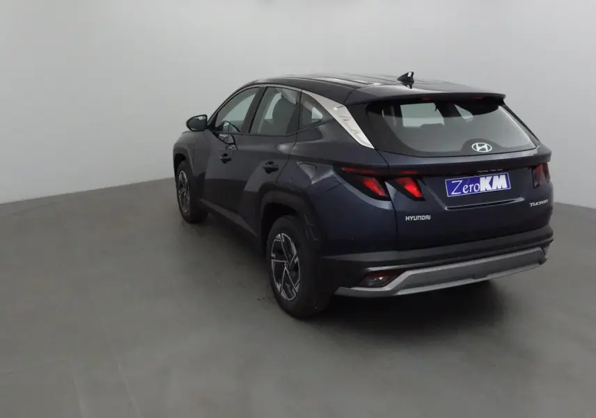 Vue 3/4 arrière droite d'un Hyundai Tucson 2025 bleu Salling avec feux arrière LED et jantes alliage 17 pouces.