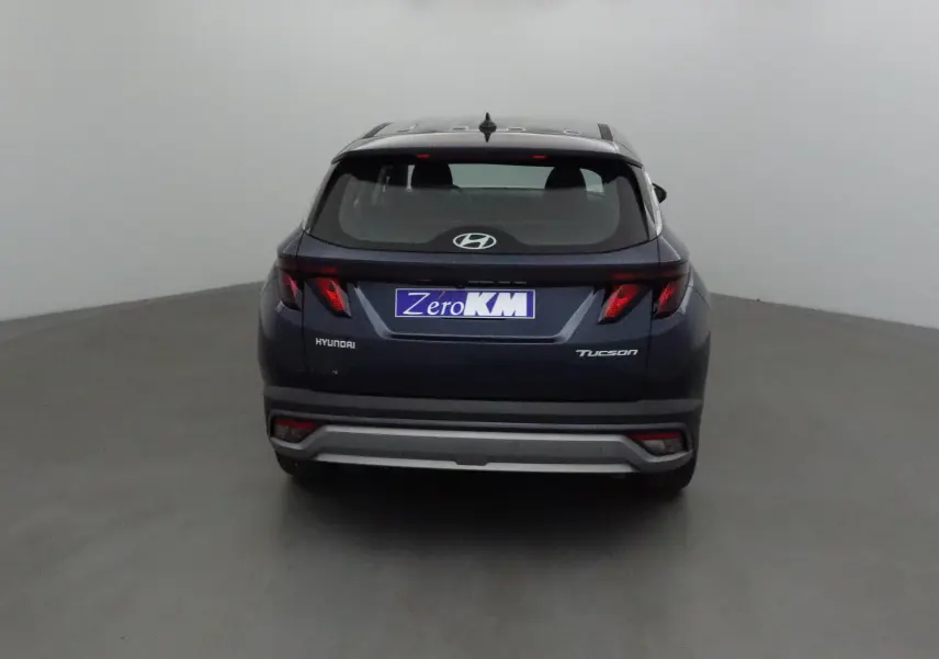 Vue arrière d'un Hyundai Tucson bleu Salling 2025 avec logo et plaques visibles dans un studio neutre.