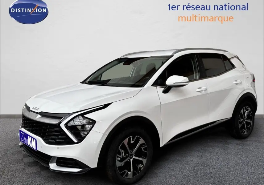 KIA SPORTAGE blanc nacré métal en 3/4 avant droit, avec jantes noires et détails de calandre distinctifs.