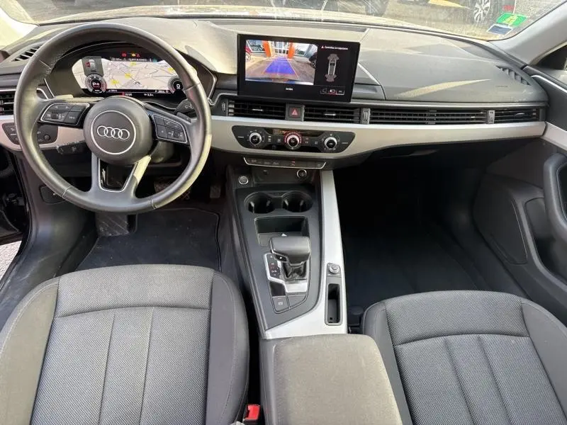 Vue intérieure avant de l'Audi A4 Avant 30 TDI 2022, tableau de bord noir avec écran central et volant cuir multifonctions.