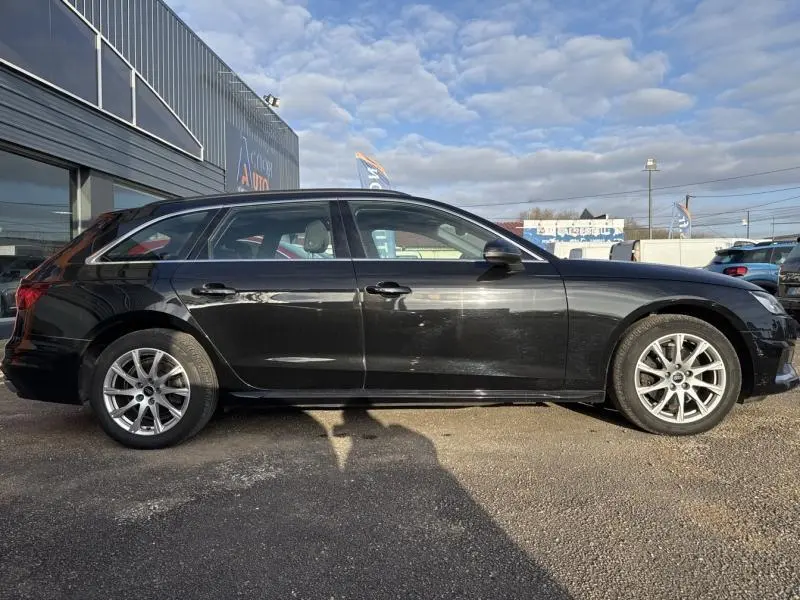 Profil côté gauche d'une Audi A4 Avant 30 TDI noire brillante, jantes alu 17 pouces, stationnée en extérieur.