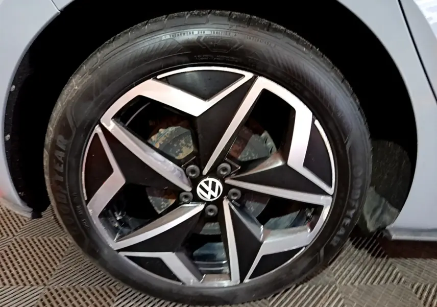 Gros plan sur la jante alliage noir et argent avec logo Volkswagen d'une Volkswagen ID.3 gris foncé.