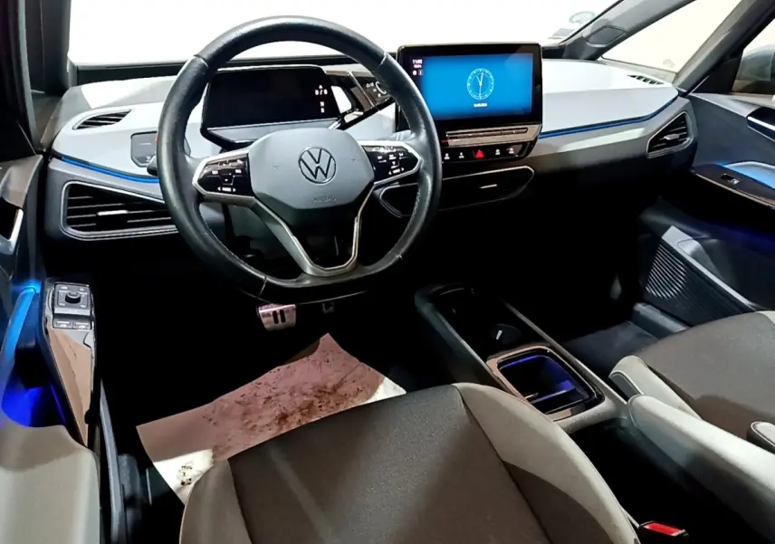 Vue intérieure avant du Volkswagen ID.3 77 kWh Pro S 2022, tableau de bord gris clair avec écran tactile central lumineux.