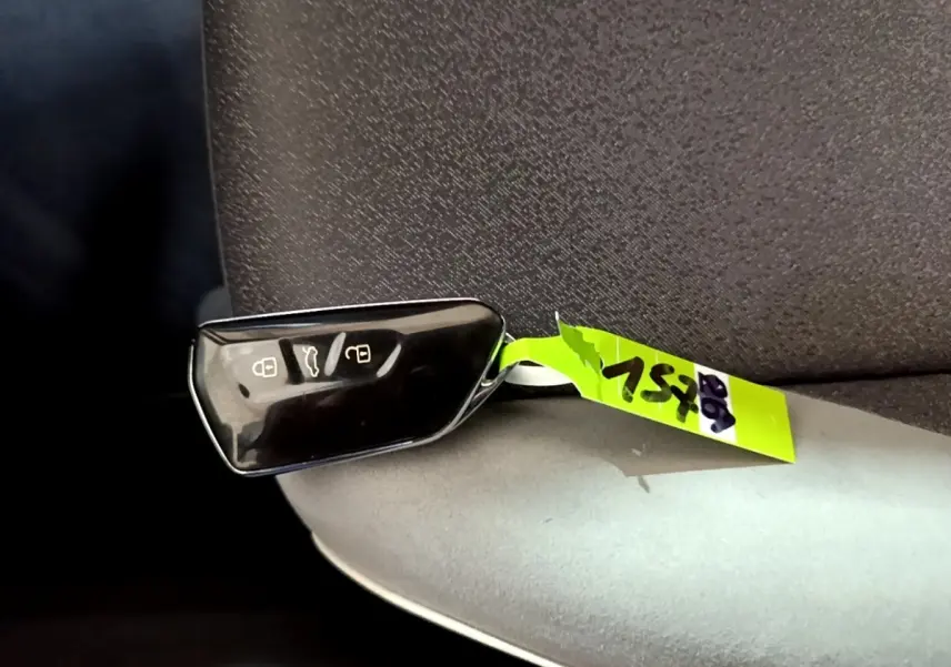 Télécommande noire de Volkswagen ID.3 77 kWh Pro S posée sur un siège gris, vue rapprochée intérieure.