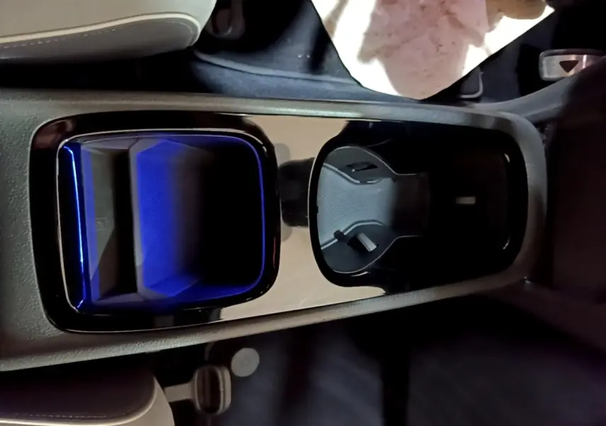 Vue rapprochée de la console centrale du Volkswagen ID.3 77 kWh Pro S, avec porte-gobelets et éclairage bleu intérieur.