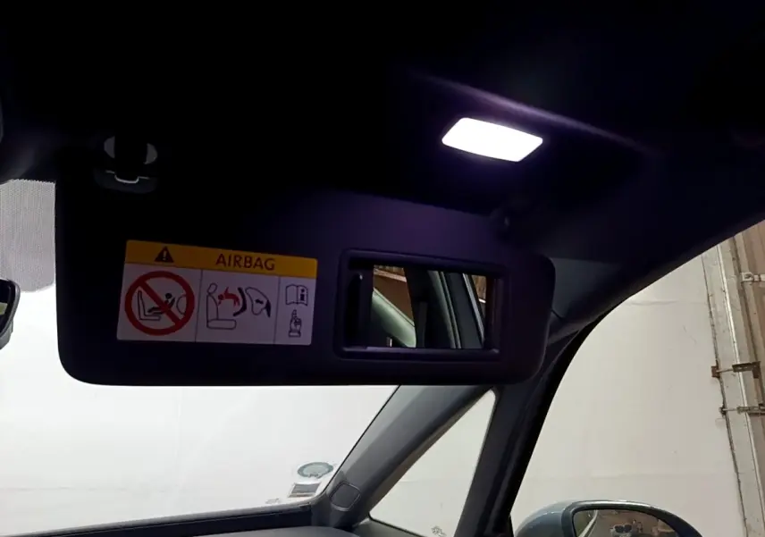 Miroir de courtoisie éclairé sur pare-soleil côté conducteur dans l’habitacle gris foncé d’une Volkswagen ID.3 77 kWh Pro S.