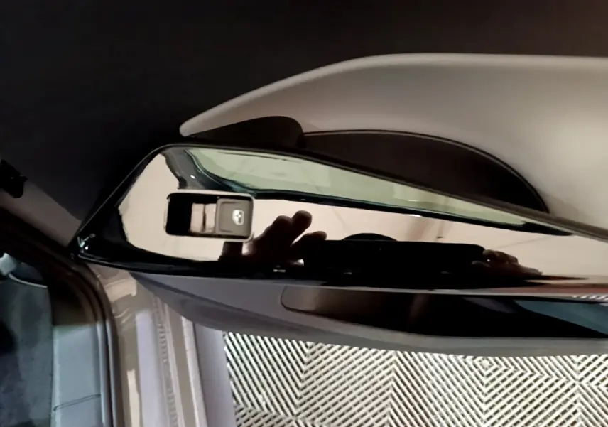 Gros plan sur le rétroviseur extérieur droit noir brillant du Volkswagen ID.3 gris foncé, intérieur partiel visible.