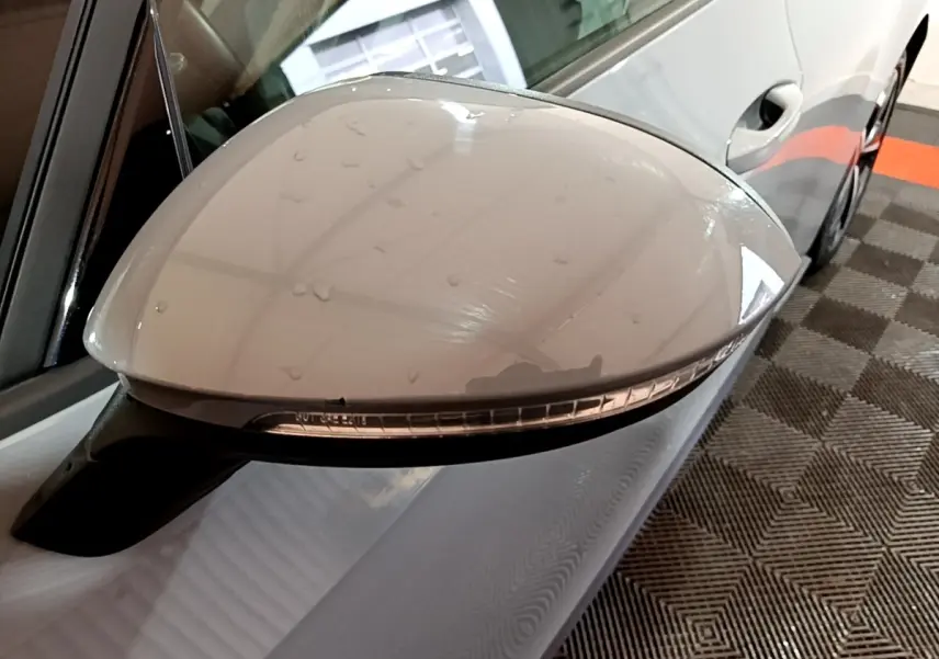 Rétroviseur côté gauche gris foncé du Volkswagen ID.3 77 kWh Pro S avec clignotant intégré, vue rapprochée en intérieur.