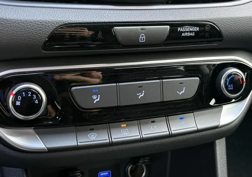 Gros plan sur la console centrale de la Hyundai i30 SW 2025, montrant les commandes de climatisation et ventilation.