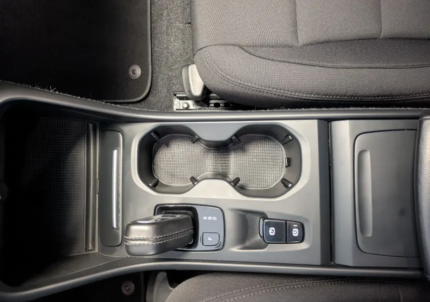 Vue plongeante sur la console centrale noire du Volvo XC40 Momentum 2021, avec levier de vitesse et porte-gobelets.
