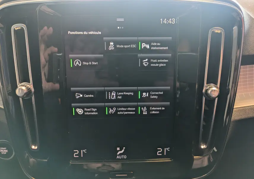 Écran tactile central du Volvo XC40 Momentum 2021 montrant les fonctions d’aide à la conduite et la climatisation à 21°C.