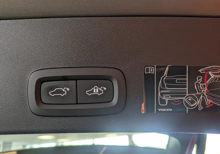 Boutons de commande pour ouverture et verrouillage électrique du coffre, situés à l'intérieur du hayon d'un Volvo XC40 marron clair.