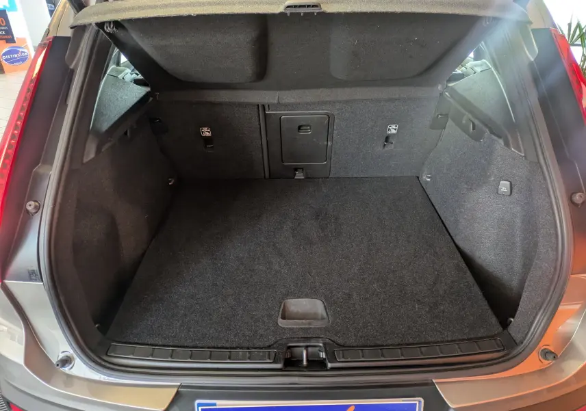 Vue arrière ouverte du coffre spacieux et propre d’un Volvo XC40 marron clair 2021 Momentum.