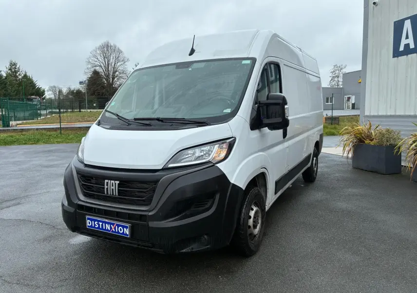 Fourgon FIAT Ducato blanc en 3/4 avant droit, avec calandre noire et plaque Distinxion visible.