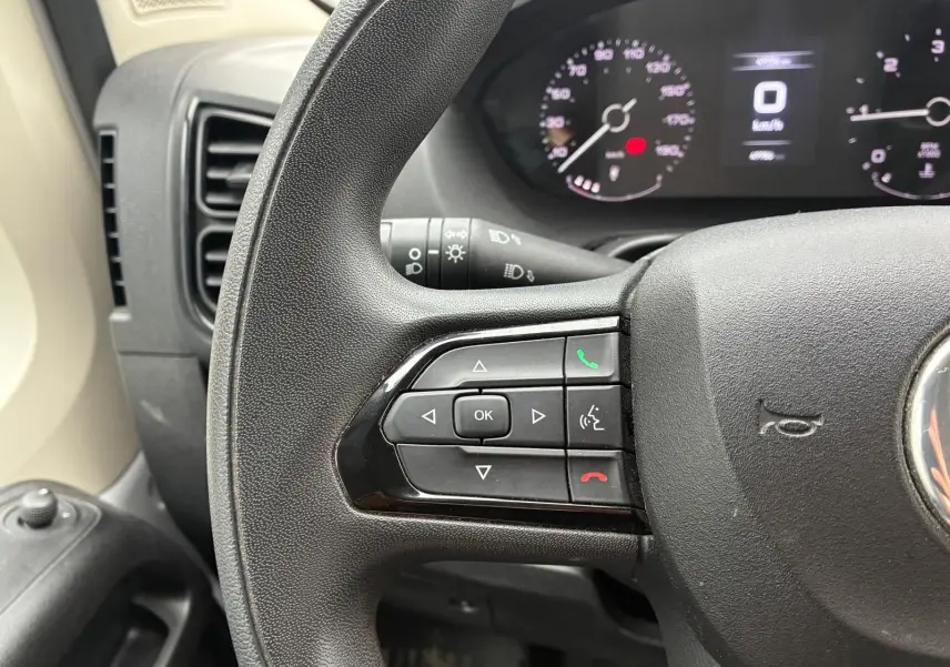 Gros plan sur le volant côté gauche du Fiat Ducato Fourgon 2023 avec commandes intégrées et tableau de bord numérique.