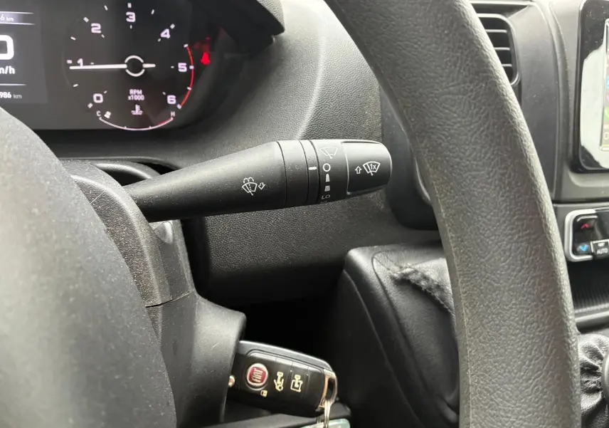 Vue rapprochée de l’intérieur du Fiat Ducato 2023, montrant le volant noir, le compteur et la clé insérée côté gauche.