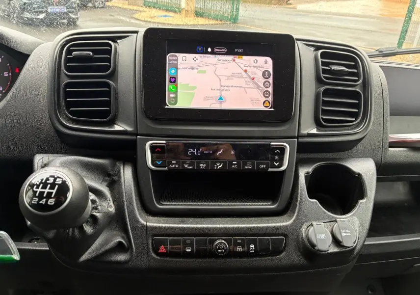 Vue intérieure centrée sur la console centrale du Fiat Ducato Fourgon 2023 avec écran tactile et levier de vitesses manuel.