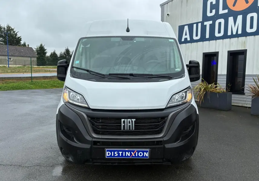 Vue frontale d’un FIAT Ducato Fourgon blanc 2023 avec calandre noire et plaque Distinxion visible.