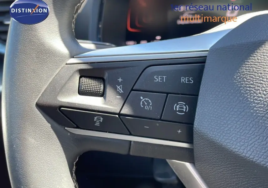 Gros plan sur les commandes au volant noir du SEAT Arona 2025, version essence, avec boutons de régulateur de vitesse et assistance.