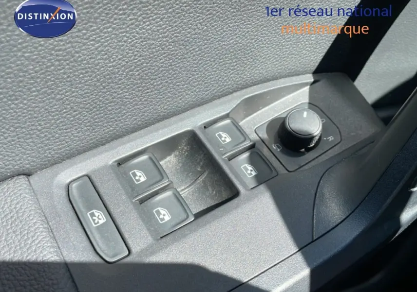 Gros plan sur les commandes des vitres électriques et rétroviseurs côté conducteur d'une SEAT Arona blanc toit noir.